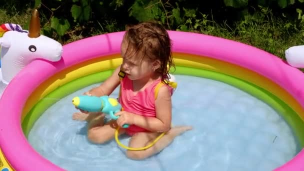 Een Kind Een Klein Opblaasbaar Zwembad Schiet Water Uit Een — Stockvideo