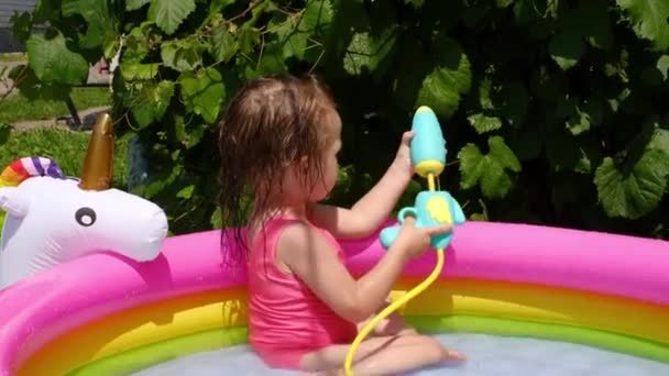 Child Shoots Water Jet Pistol Grape Bush While Swimming Inflatable — Stock Video