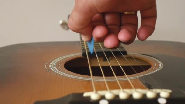 Людина Тягне Сталеві Струни Акустичної Гітари Піком Витягуючи Звук Баса — стокове відео