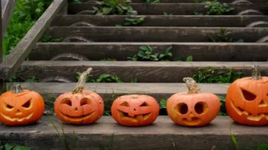 Değişik duygulara ve boyutlara sahip boş balkabakları evin önündeki eski tahta bir basamakta sıralanmış duruyor. Cadılar Bayramı için dekor. jack o' lantern
