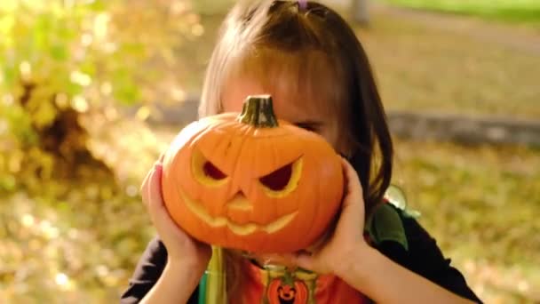Girl Looks Out Pumpkin Carved Sinister Face Evil Look Holding — Stock Video