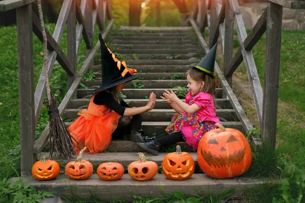 의상을 자매가 계단에 손바닥을 가지고 있습니다 조각된 Jack Lantern Pumpkins — 스톡 사진