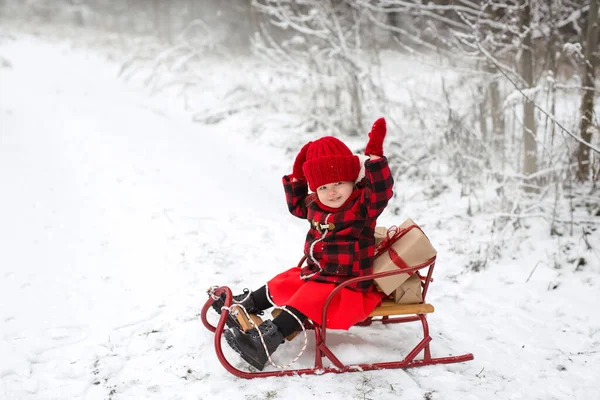 Ein Kind Rot Karierten Mantel Sitzt Einem Schlitten Mit Weihnachtsgeschenken — Stockfoto