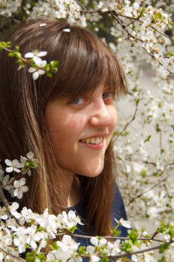 Kız beyaz bir çiçek ağacında.