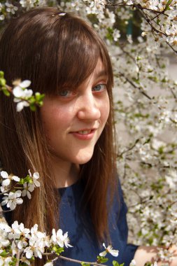 Kız beyaz bir çiçek ağacında.