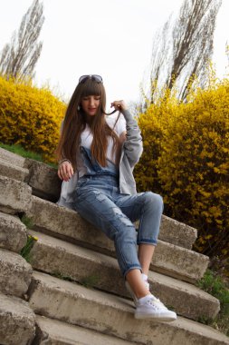 Tulumlu kız merdivenlerde oturuyor.