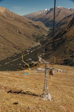 İnsanlar bir dağ teleferiğinde yükselir ve düşer.