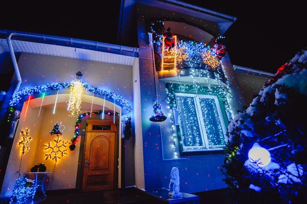 Ev Noel tatili ışıkları ve süslemeleri ile süslenmiş. Noel Baba ve Noel ağaçları gece aydınlatmalı.