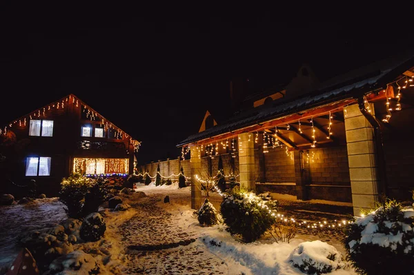 Karlı bir bahçede Noel ışıkları.