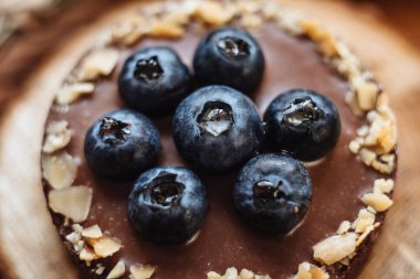 Çikolatalı tart üzerinde bir grup yabanmersini yakın plan. Lezzetli ve kullanışlı dut vitaminleri. Güzel taze yaban mersininin bileşimi. Meyve suyuyla olgunlaşmış yaban mersini..