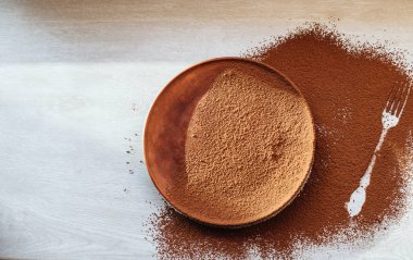 Üzerinde çatal izi olan kakao serpilmiş kahverengi bir tabak. Açık ahşap arka planda boş bir tabak. Mesaj için yer. Kopyalanmış uzay. Diyet kavramı