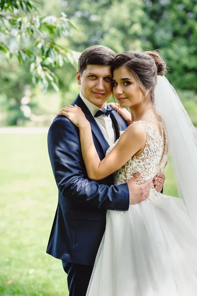 Noivo Smoking Azul Está Abraçando Noiva Vestido Branco Com Uma — Fotografia de Stock