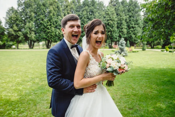 幸せなカップルの花嫁は緑の公園の背景に顔を作っています 閉じろ — ストック写真