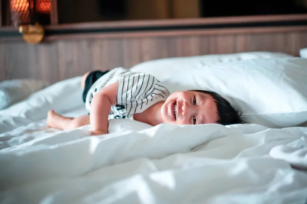 줄무늬 티셔츠를 소년이 긴장을 따뜻하고 부모의 침대에 스러운 아기의 초상화 — 스톡 사진