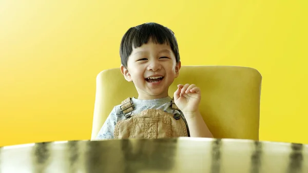 얼굴로 크림의자에 아이의 초상화 귀여운 아이는 캐주얼 수트를 배경에 미소를 — 스톡 사진