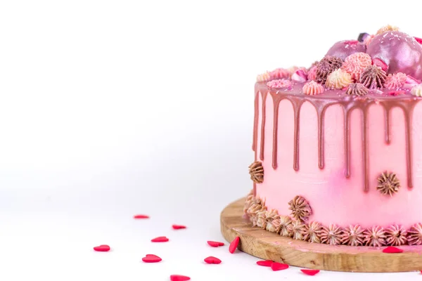 Bithday dort s růžovou smetanou a polevou, posypaný třpytkami a sladkostmi ve tvaru srdíčka kopírují prostor. Domácí dort na bílém pozadí. — Stock fotografie