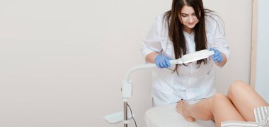 Uzun siyah saçlı yakışıklı bir kozmetik uzmanı elektroliz ameliyatı yapıyor. Güzellik uzmanının ofisinde. Yakın plan..