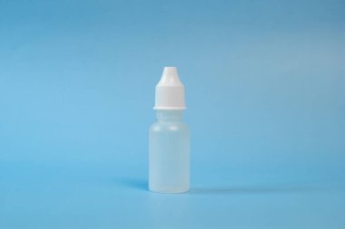 Burun ve göz damlaları için plastik kap, şişe. Mavi arka planda izole edilmiş. Yazı için uygun bir yer. Kopyalama alanı