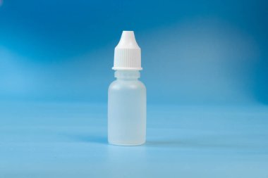 Burun ve göz damlaları için plastik kap, şişe. Mavi arka planda izole edilmiş. Yazı için uygun bir yer. Kopyalama alanı