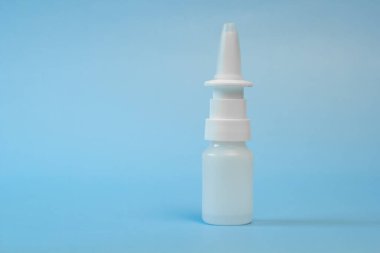 Burun ve göz damlaları için plastik kap, şişe. Mavi arka planda izole edilmiş. Yazı için uygun bir yer. Kopyalama alanı