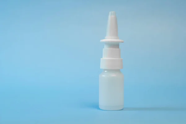 Plastic container for nose and eye drops, bottle. isolated on blue background. Place for an inscription. Copyspace