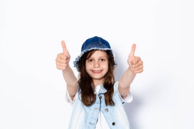 Komik siyah saçlı kız elleriyle klas jestler yapıyor. Hafif bir arkaplanda. Metin için boşluk.