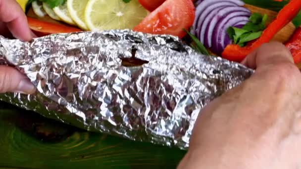 Freshly baked fried mackerel in foil with lemon and different vegetables, rosemary and spices. Healthy delicious mediterranean tasty food. Close-up. — Stock Video