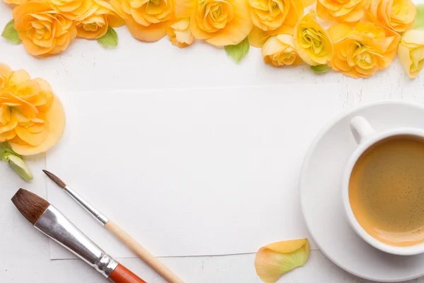 Bloc-notes vierge, fleurs, brosses et tasse de café sur woo blanc — Photo