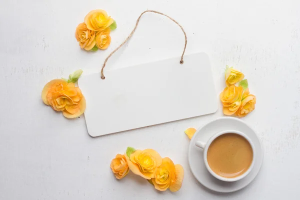 Styrelsen för not, blommor och kopp kaffe över vita trä rygg — Stockfoto