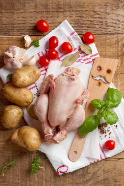 Whole chicken with spatula, spices and vegetables — Stock Photo, Image