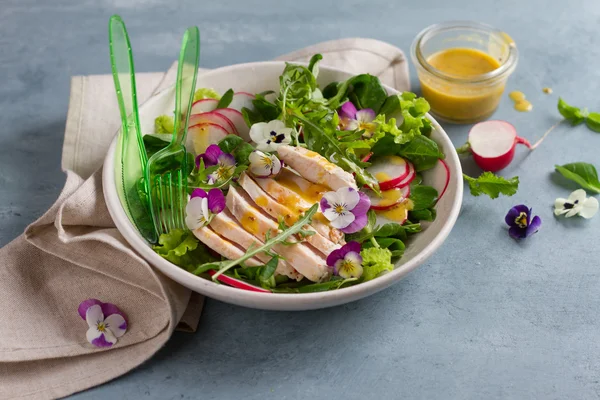 Весенний салат с редиской, куриной грудью и съедобным цветком — стоковое фото