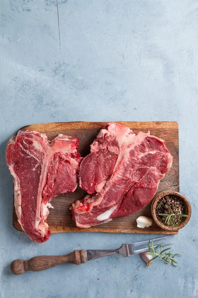 Bistecca di T-bone cruda spessa con condimento — Foto Stock