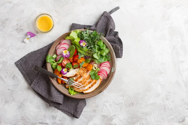 Весенний салат с овощами, куриной грудью и съедобной флове — стоковое фото