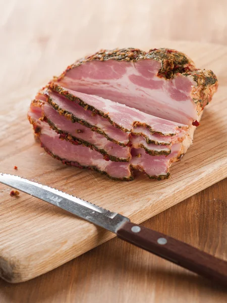 Smoked meat with spices and knife — Stock Photo, Image