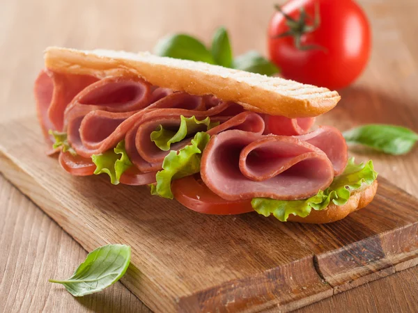 Бутерброд з шинкою, помідорами та салатом — стокове фото