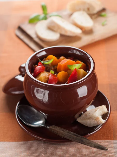 Hot goulash soup in pot with slice of bread — Stock Photo, Image