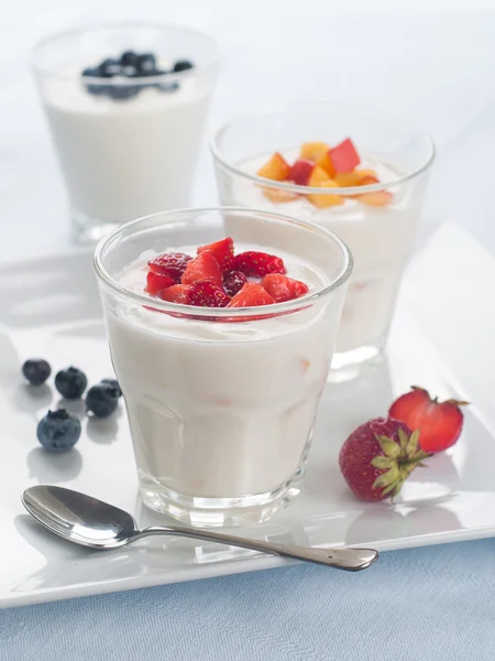 Glazen met fruitbomen en bessen yoghurt — Stockfoto