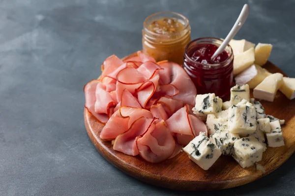 Servierplatte mit Speck, Käse und Soße — Stockfoto