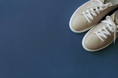 Köşede mavi arka planda bej ayakkabılar.