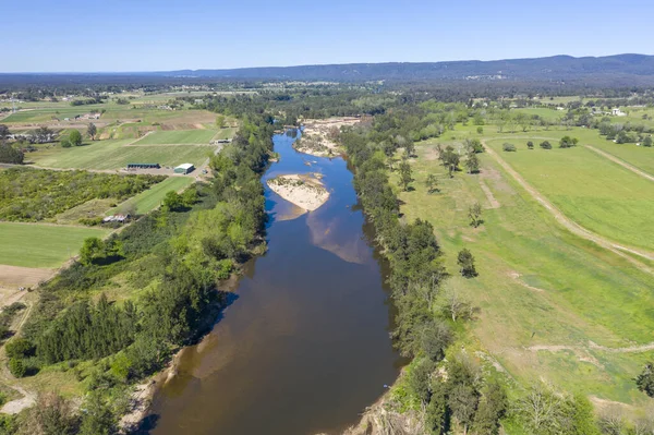 Aerial view of the Hawkesbury River running through agricultural farmland in regional New South Wales in Australia