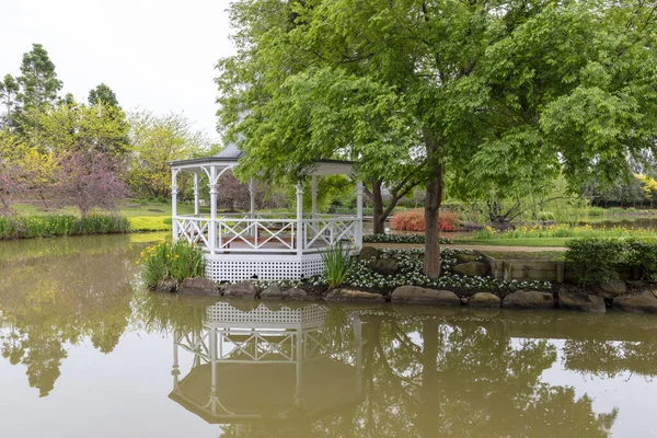 一座白色的宝塔 周围是一个大花园池塘里的树木和花朵 — 图库照片