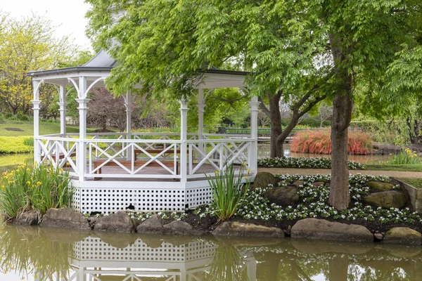 一座白色的宝塔 周围是一个大花园池塘里的树木和花朵 — 图库照片