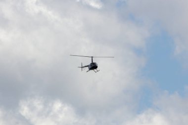 Avustralya 'nın bulutlu gökyüzünde turistlerle birlikte uçan bir helikopter.
