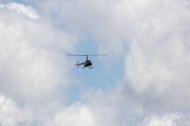 Avustralya 'nın bulutlu gökyüzünde turistlerle birlikte uçan bir helikopter.