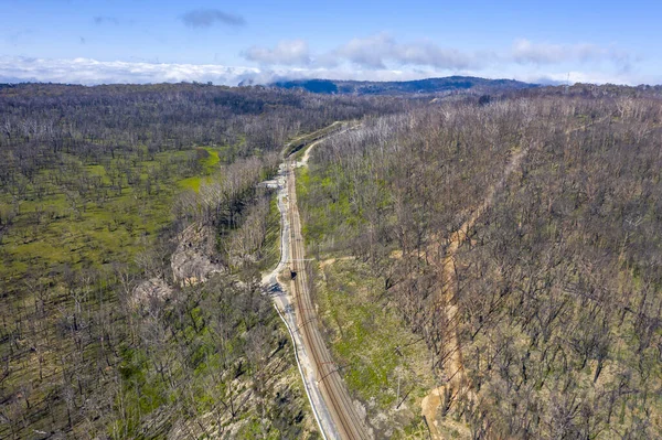 Aerial view of a train line running through and area of forest regeneration after bushfire in Dargan in the Central Tablelands in regional New South Wales Australia