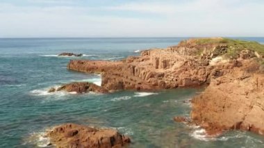 Avustralya 'nın Yeni Güney Galler bölgesindeki Port Stephens yakınlarındaki Birubi Point' te kahverengi kayaların ve Tasman Denizi 'nin mavi sularının hava görüntüleri.