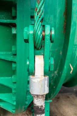 Büyük bir fındık ve paslı çelik kablo ile eski yeşil çelik bir pranganın yakın görüntüsü