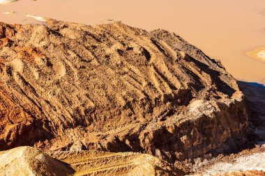 Büyük bir taş ocağında yerde duran durgun sel suyunun fotoğrafı.