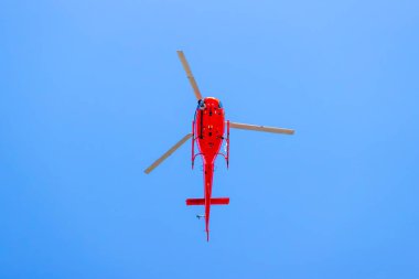 Avustralya 'da bir spor olayını filme alan kırmızı bir helikopterin fotoğrafı..