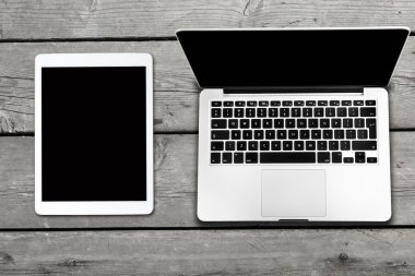 Tablet ve eski ahşap masa üstünde bilgisayar